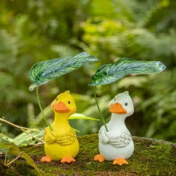 Декоративна садова фігурка «Каченя з листком» 13 см, смола, біла / жовта