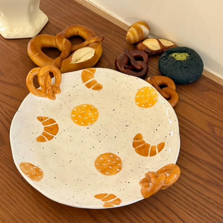 Декоративна керамічна тарілка круглої форми з дизайном випічки